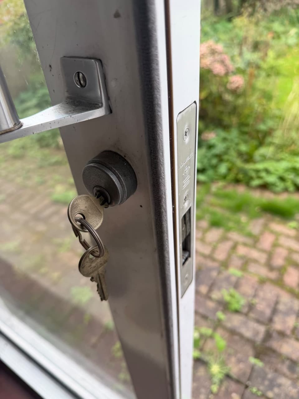 Euro cylinder and keys in a white uPVC door, with the multipoint lock keep beside it